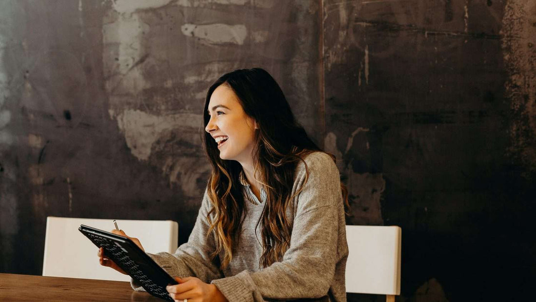 Person writing in a goal-setting journal at a desk, comparing structured planning formats for UK buyers
