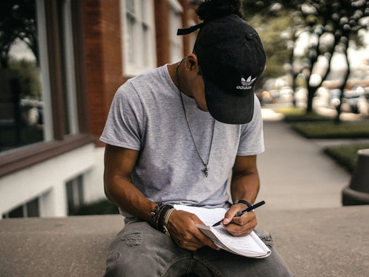 Person sitting with a notebook, pausing to reflect and plan rather than rushing into a New Year resolution