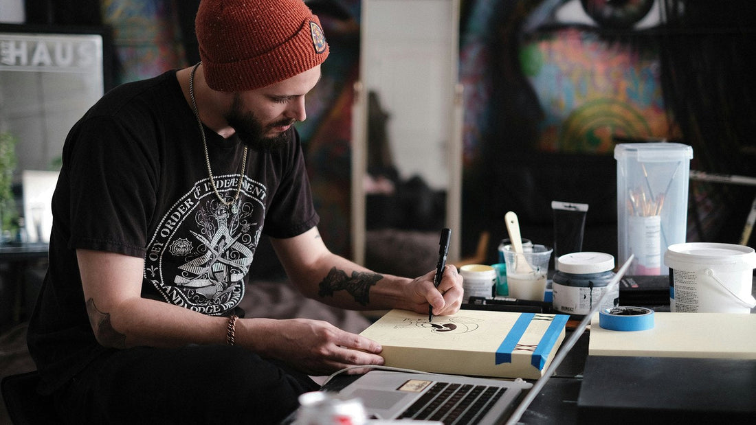 Man painting in a colourful art studio, absorbed and deliberate, living with intention