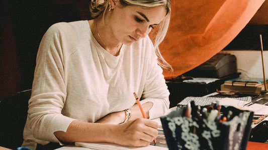 A person writing freely in a notebook, getting everything on their mind down onto the page