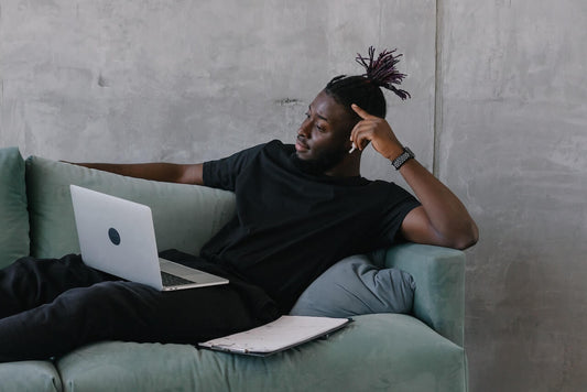 Man sat on a sofa thinking through whether to quit his job for a better opportunity