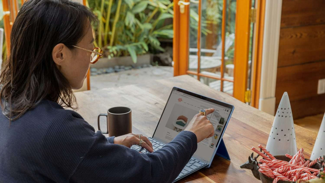 Woman working at a wooden desk with tablet in warm morning light, intentional and focused