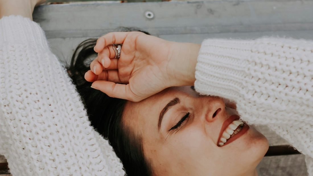 Woman lying down with an arm over her face on a Sunday evening, weighed down by the dread of the week ahead, sunday anxiety