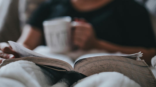 Person reading calmly at a wooden desk in soft morning light, settling into a gratitude journaling practice