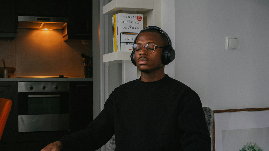 Person sitting still with eyes closed at home, using a vagus nerve exercise to calm an activated nervous system