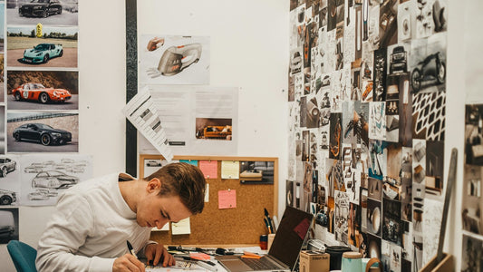 Person slumped head-down at a cluttered desk, depleted and exhausted, in the grip of burnout