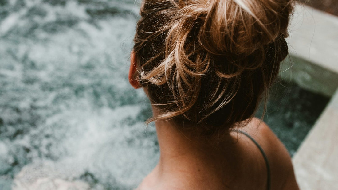 Woman in a still pool from behind, quiet and reflective, a moment of self-examination and inner doubt