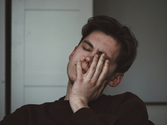 Man with hand over his face, avoiding the hard task that is the frog he hasn't eaten yet
