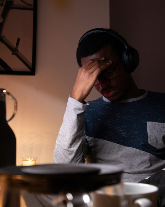 Man staring at a laptop screen late at night, unable to switch off from work despite the hour