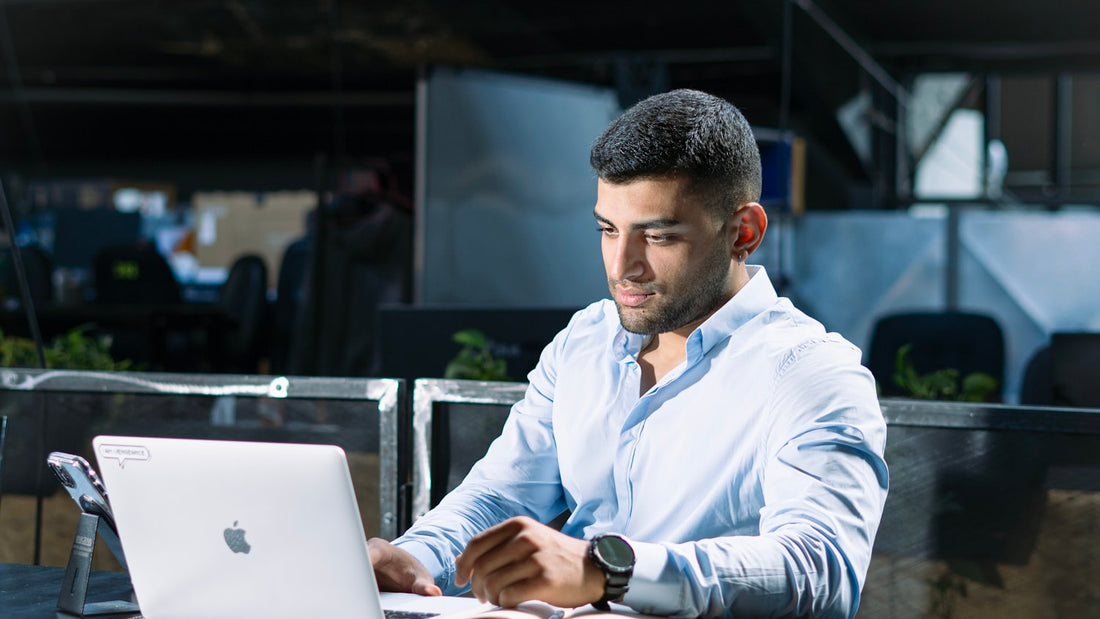 Focused man working at a laptop, thinking through how to write a personal mission statement
