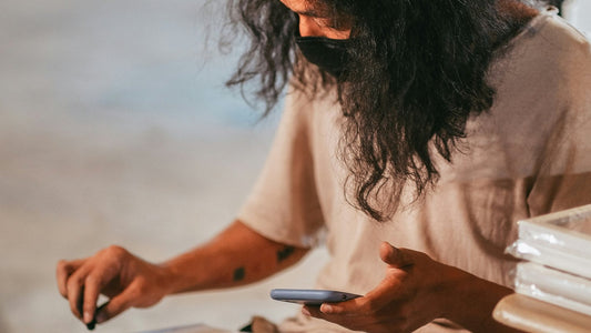 Person sitting at a desk with eyes closed and head tilted slightly back, face soft and unfocused, conveying the blurred mental state of brain fog