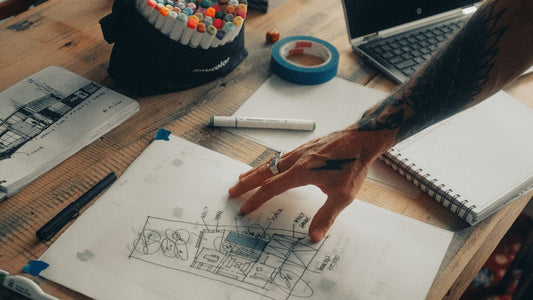 Person reviewing sketches and plans at a desk from above, finishing the year with clear purpose