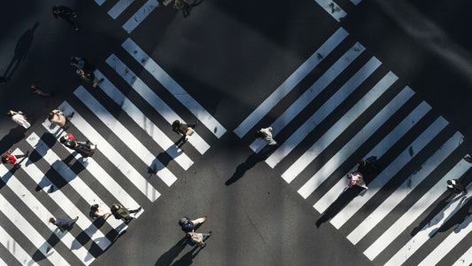 Person walking alone on a pedestrian crossing in a city, pausing to reflect, journaling concept of mental clarity