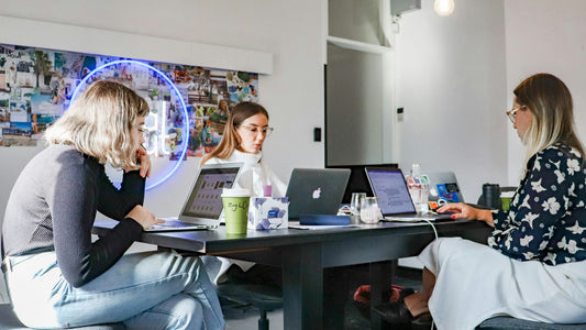 Woman with hands on her head at a laptop, overwhelmed by work stress, productivity and mental health link