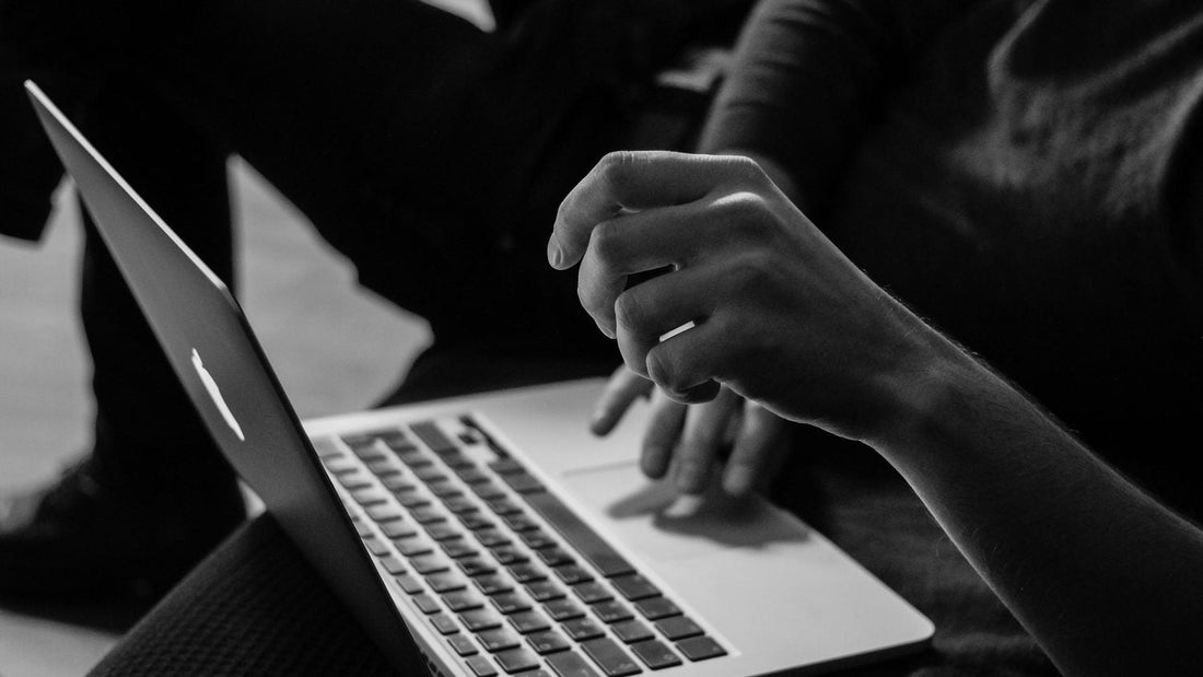 Black and white close-up of hands on a MacBook keyboard, ADHD working memory issues mean thoughts disappear mid-task mid-sentence mid-thought