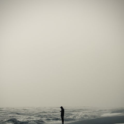 Person sitting quietly alone, the exhausted stillness characteristic of autistic burnout