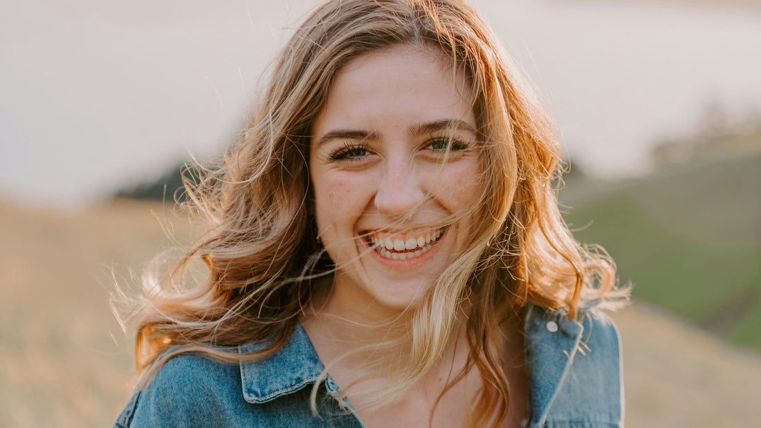 Woman smiling in golden morning light outdoors, calm and energised, morning routine