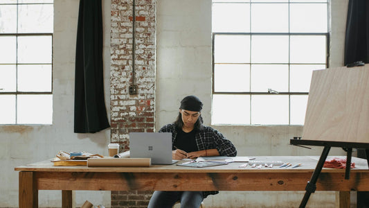 Woman writing at a large wooden desk during an end of year review, calm and focused