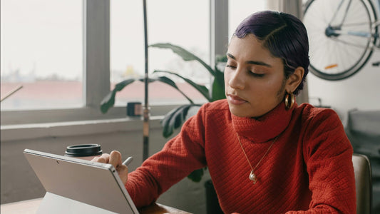 Woman writing in a journal at her desk, working through a specific prompt