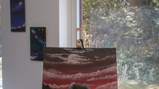 Woman gazing out of a window mid-thought, mind wandering during a quiet pause at her desk