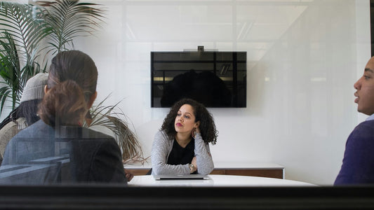 Woman writing plans into an open diary at a bright home desk, calm and focused, diary usage habit