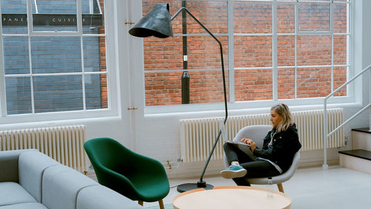 Person sitting quietly by a window looking flat and aimless, reflecting the feeling of languishing
