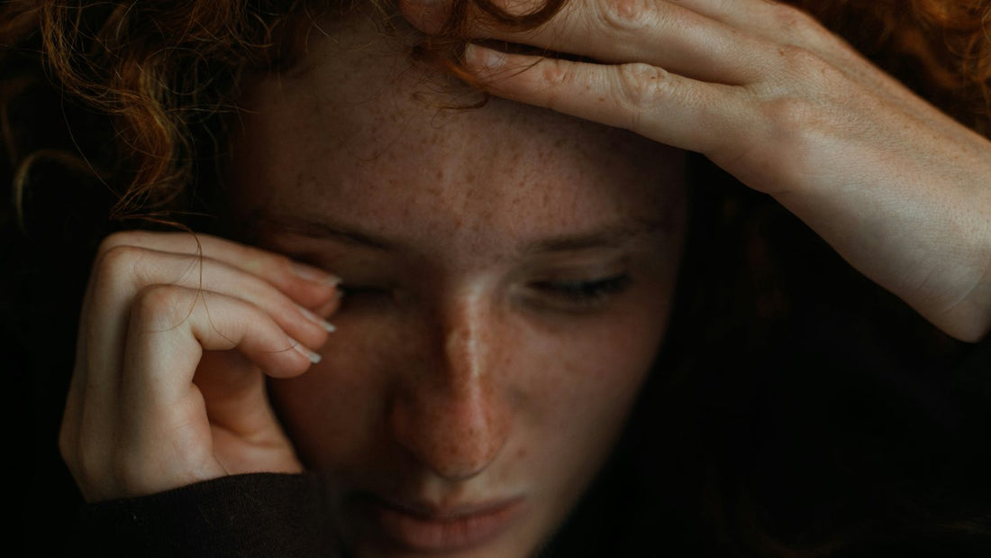 Woman with her hands on her head, overwhelmed, holding back how she actually feels