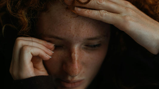 Woman with her hands on her head, overwhelmed, holding back how she actually feels