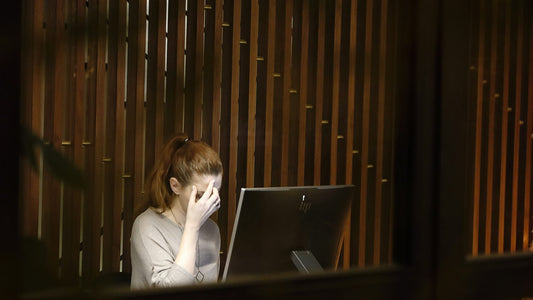 Person at a busy desk with multiple screens feeling information overload as their brain fills up by midday