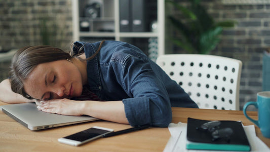 Woman with her head down at a desk, overwhelmed by anxiety before using a grounding technique