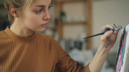 Woman absorbed in painting at an easel in a studio, lost in hyperfixation on a creative task