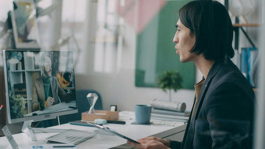 Man focused at a monitor in a tidy workspace, managing his time and attention on one task
