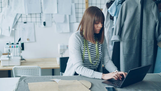 Woman smiling while on a call at her laptop in a bright creative studio, engaged and confident in her work
