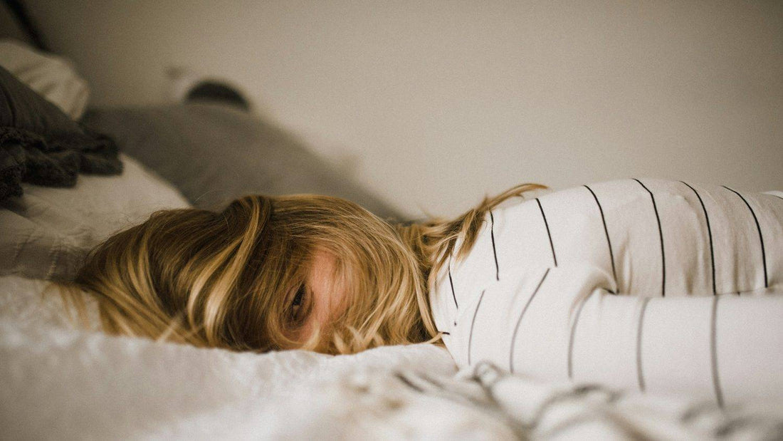 Woman lying awake in bed at night, eyes open and unable to switch off despite exhaustion