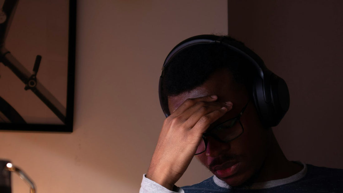 Man sitting at a desk with his head in his hands, stuck in front of an overwhelming to-do list — the ADHD planning problem this guide is written to solve